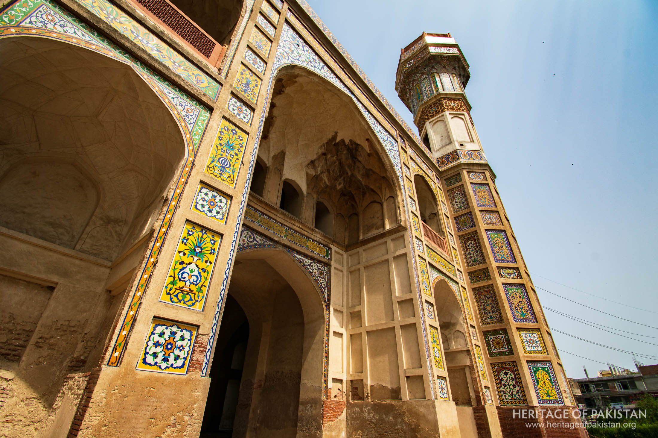 The building features iwans, muqarnas, Quranic calligraphy, and unique widening minaret forms.